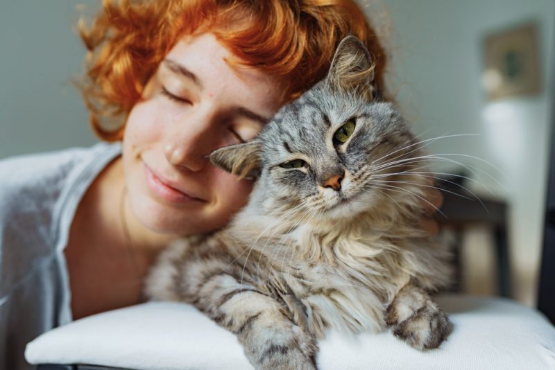 teenager cat owner cuddling with pet cat